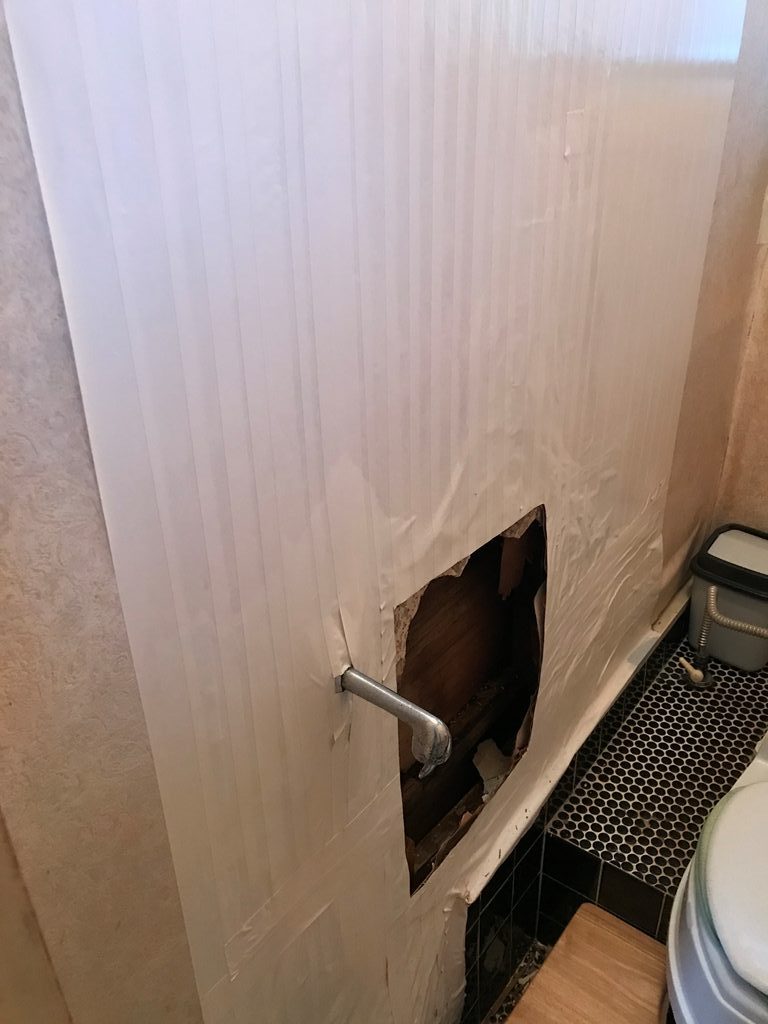 トイレの壁が腐朽して穴が空いた状態の写真
